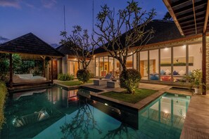 A modern pool area with a clear pool, lounge chairs, and a covered seating area. - Villa Becca Seminyak (Seminyak)