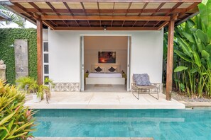 A private pool area with a covered seating area, a bed with pillows, and a painting on the wall. - Villa Becca Seminyak (Seminyak)