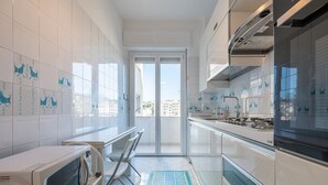 Une cuisine moderne avec des meubles blancs, un four à micro-ondes et une cuisinière.