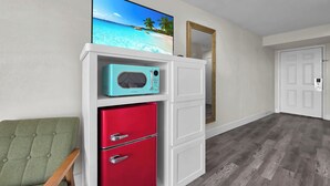 A room with a red refrigerator, a teal microwave, and a green chair. - Crystal Palace Resort (Port Bolivar)