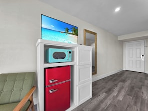 A room with a red refrigerator, a teal microwave, and a green chair. - Crystal Palace Resort (Port Bolivar)