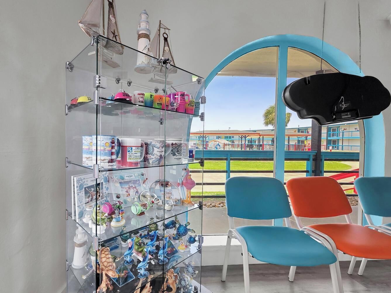 A seating area with colorful chairs and a glass display case with various items.