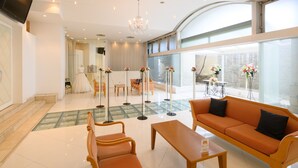 A modern hotel lobby with a seating area, a dress form, and a chandelier. - Sabae City Hotel (Sabae)