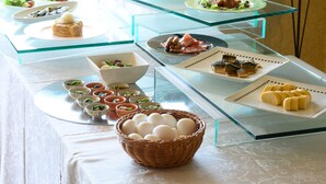 A buffet table with various dishes and a basket of eggs. - Sabae City Hotel (Sabae)