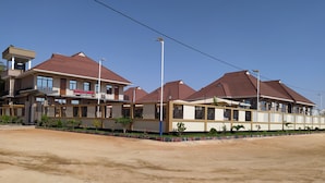 A hotel with multiple buildings, a parking area, and a clear sky. - Hancol Hotel (Dodoma)