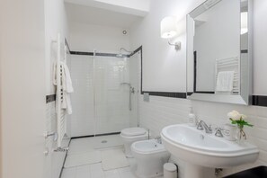Apartamento básico, varias camas | Baño | Ducha, secador de pelo, toallas y jabón