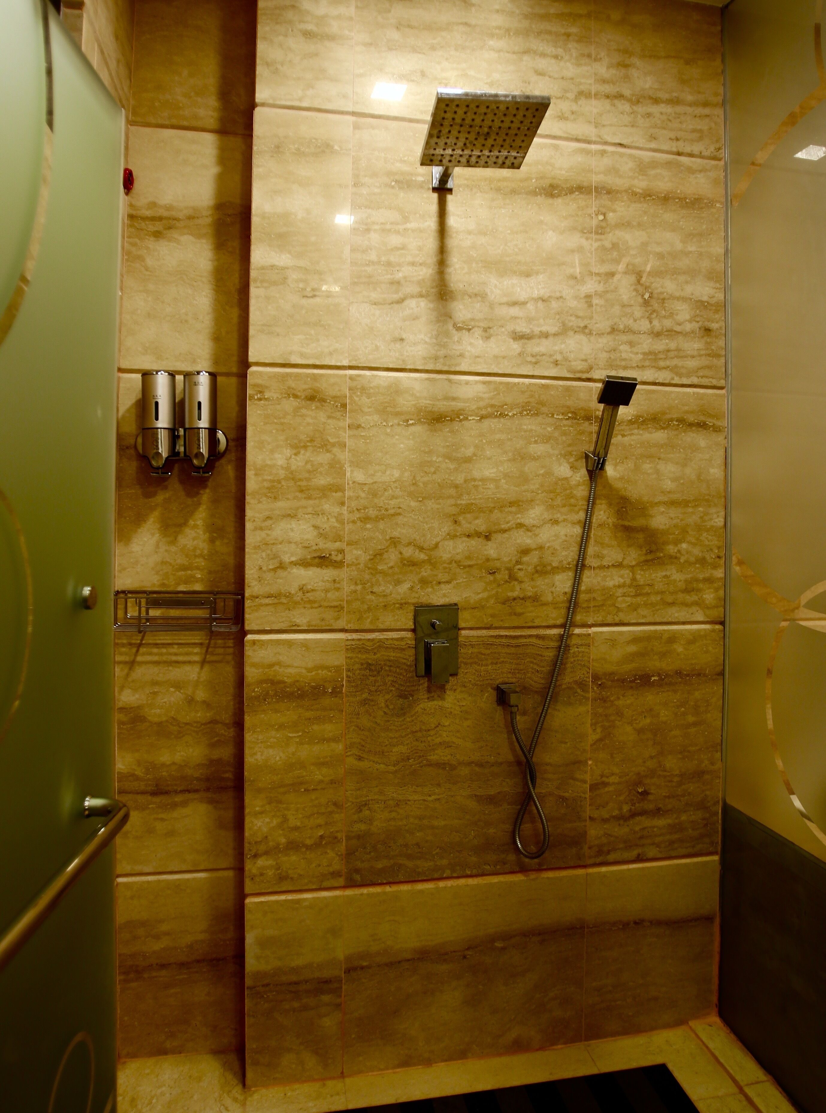 A bathroom with a shower, a towel rack, and a toilet.