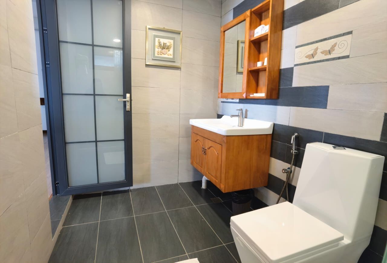 A modern bathroom with a toilet, sink, and shower.