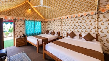 A room with two beds, a ceiling fan, patterned wallpaper, and a view of the outdoors.