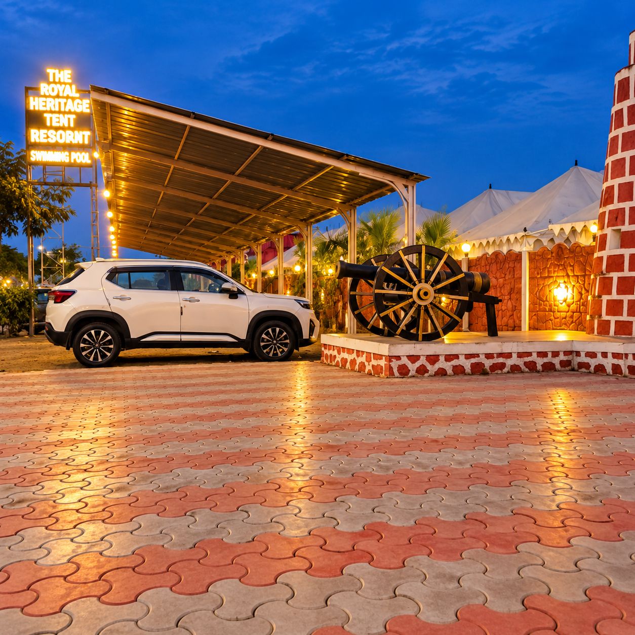 A white SUV parked under a covered area with a sign for 'The Royal Heritage Tent Resort Swimming Pool'.