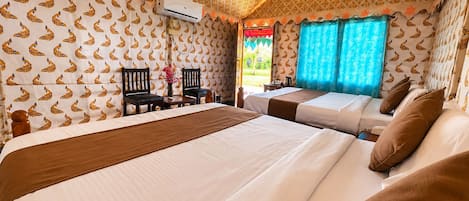 A hotel room with two beds, a ceiling fan, and patterned wallpaper.