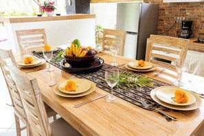 Enjoy meals in this dining area with a table set for four, featuring a central bowl of fruit and a woven placemat.