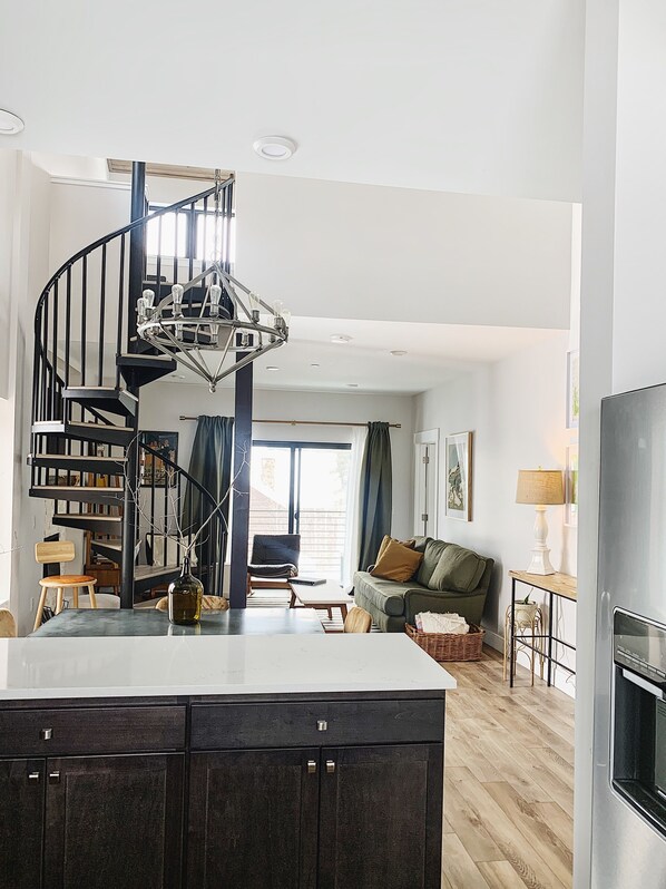 Spacious kitchen with central island, spiral staircase, and dining area.