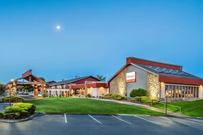 A hotel with a modern design, featuring a prominent 'NOMAD' sign, a parking lot, and well-maintained landscaping. - Pleasant Stay, Convenient Location! Upscale Unit Near Attractions, Pool, Parking (Kennewick)