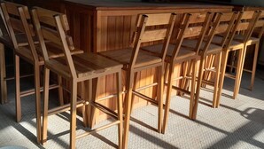 Wooden chairs and a table in a room with a patterned floor.