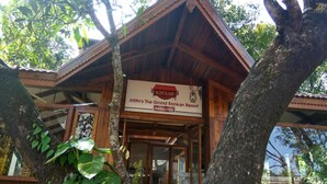 A wooden building with a sign for Atithi's The Grand Konkan Resort. - Atithi Lodge (Ratnagiri)