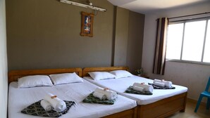 A hotel room with two wooden beds, white linens, and towels. - Atithi Lodge (Ratnagiri)
