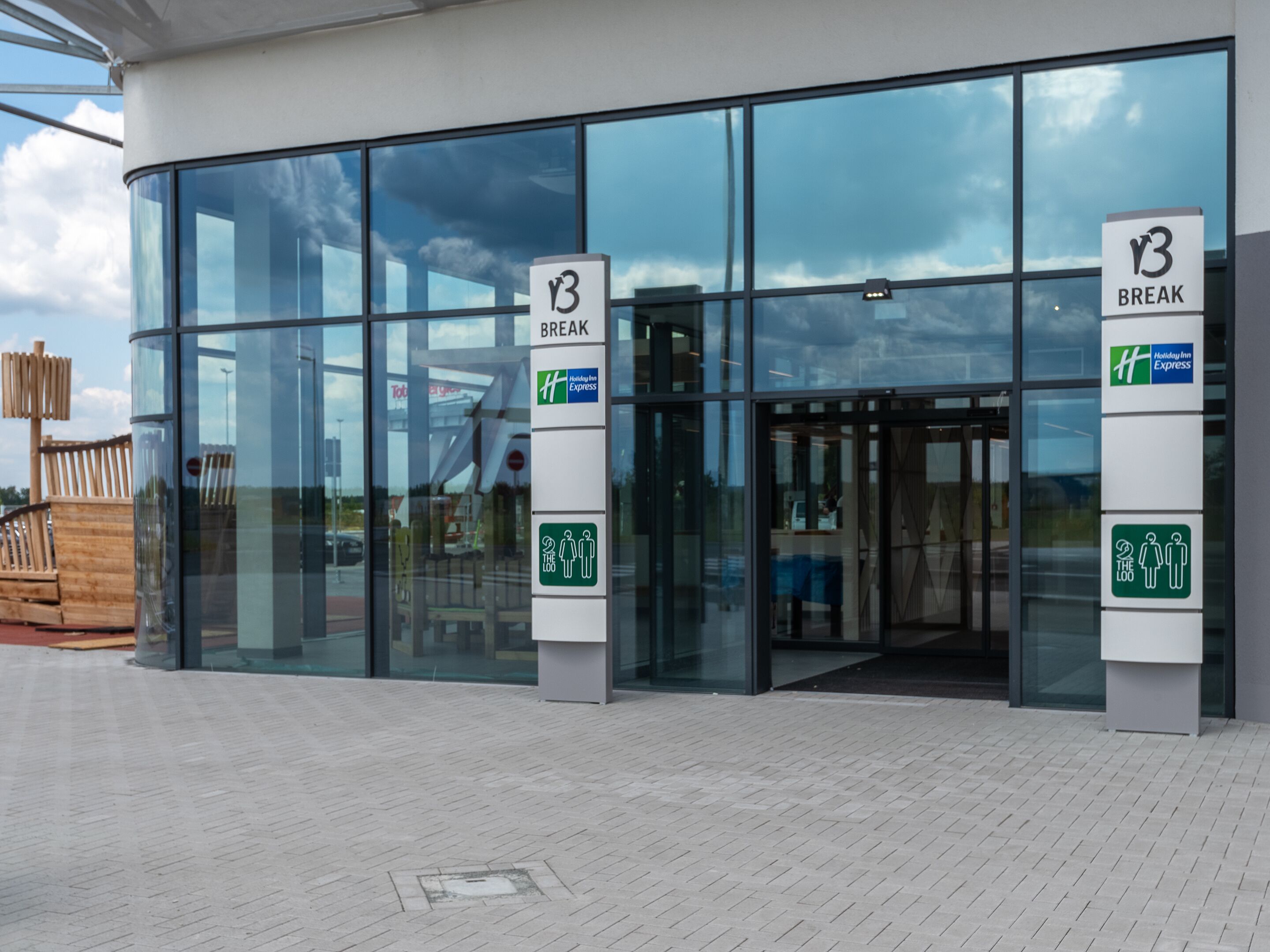 A modern building with large glass windows and a sign indicating a 'Break' area.