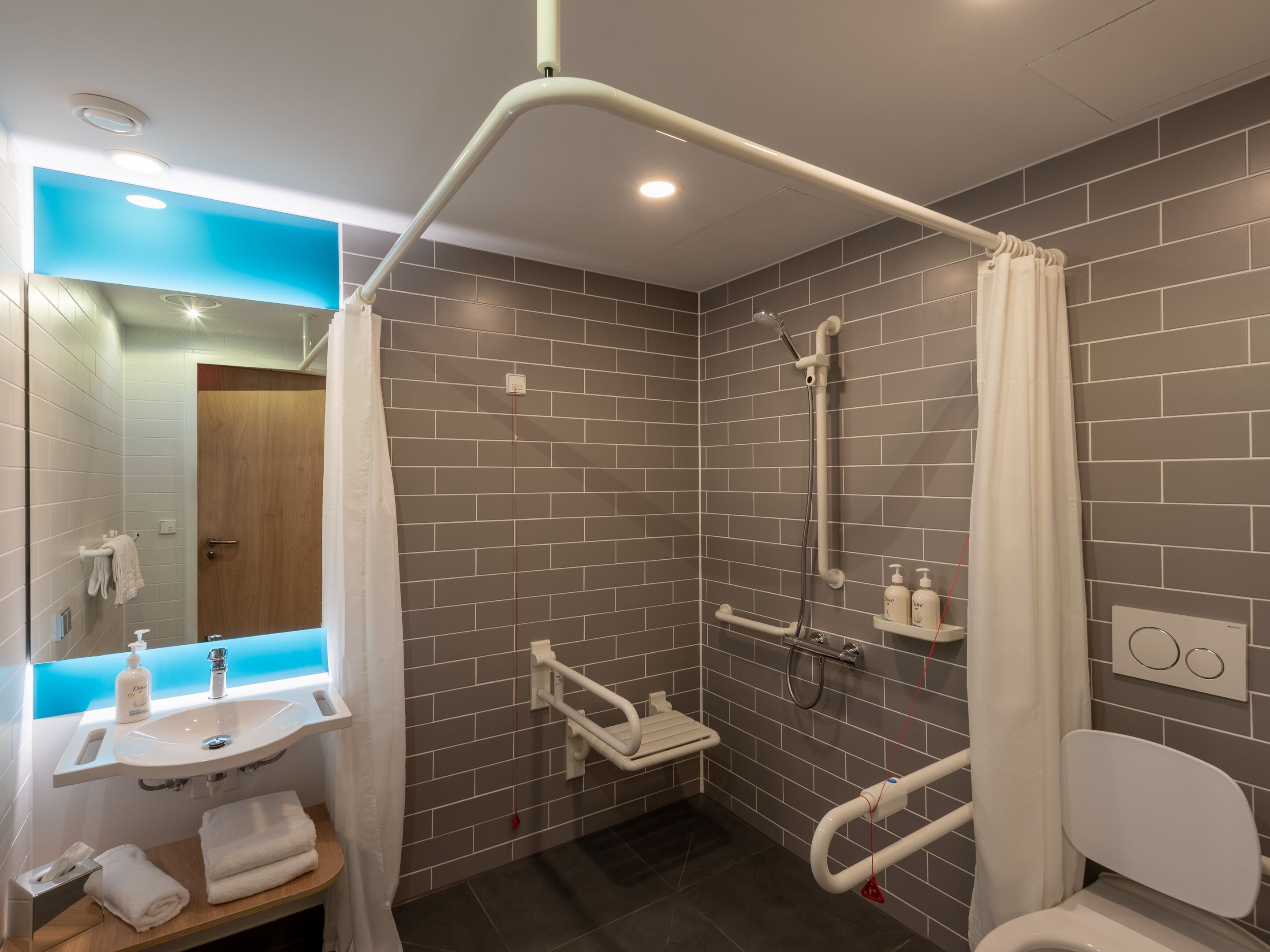 A modern bathroom with a shower, toilet, and sink.