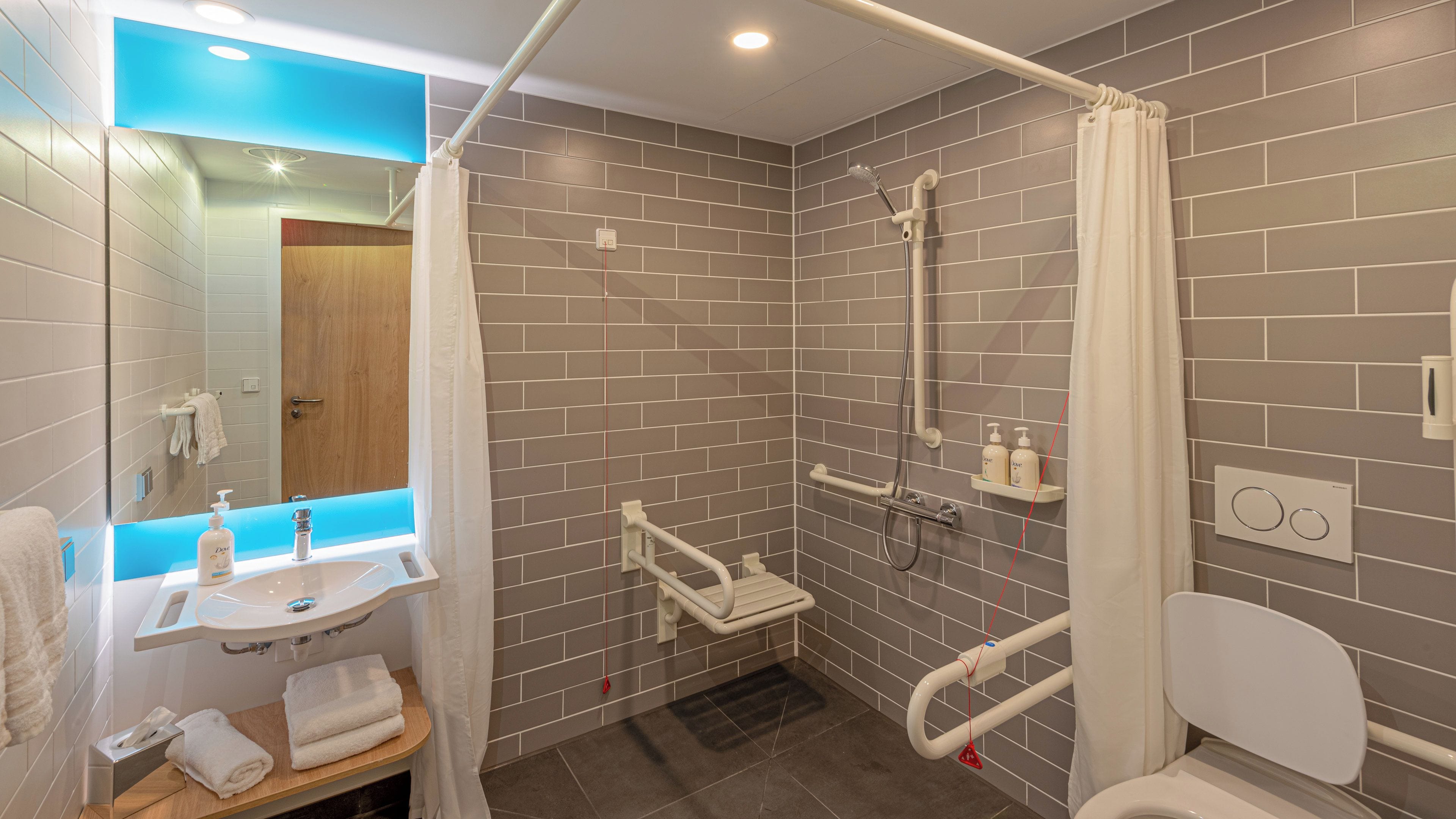 A modern bathroom with a shower, a sink, and a toilet.