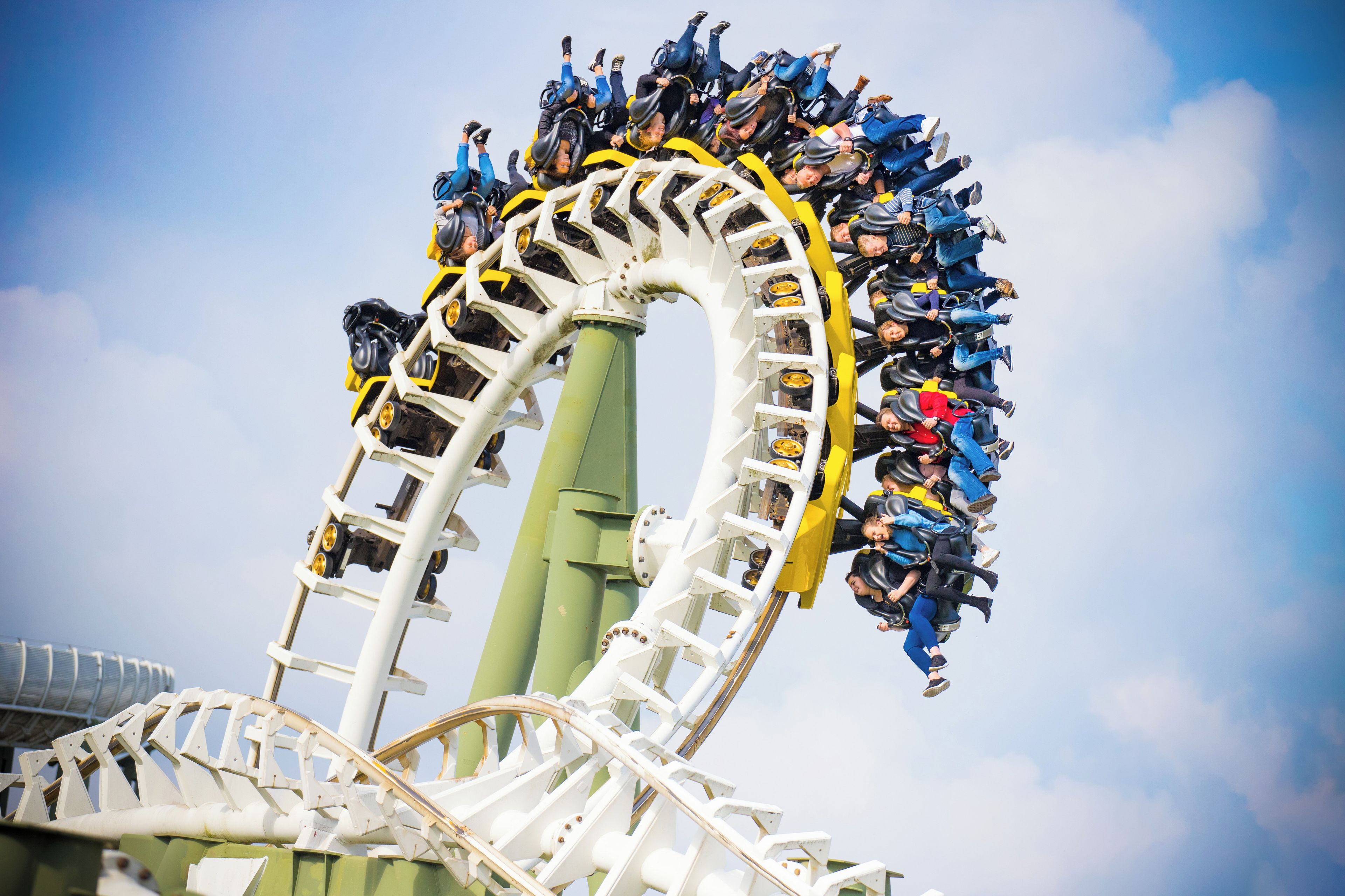 A roller coaster in motion with passengers seated in rows.