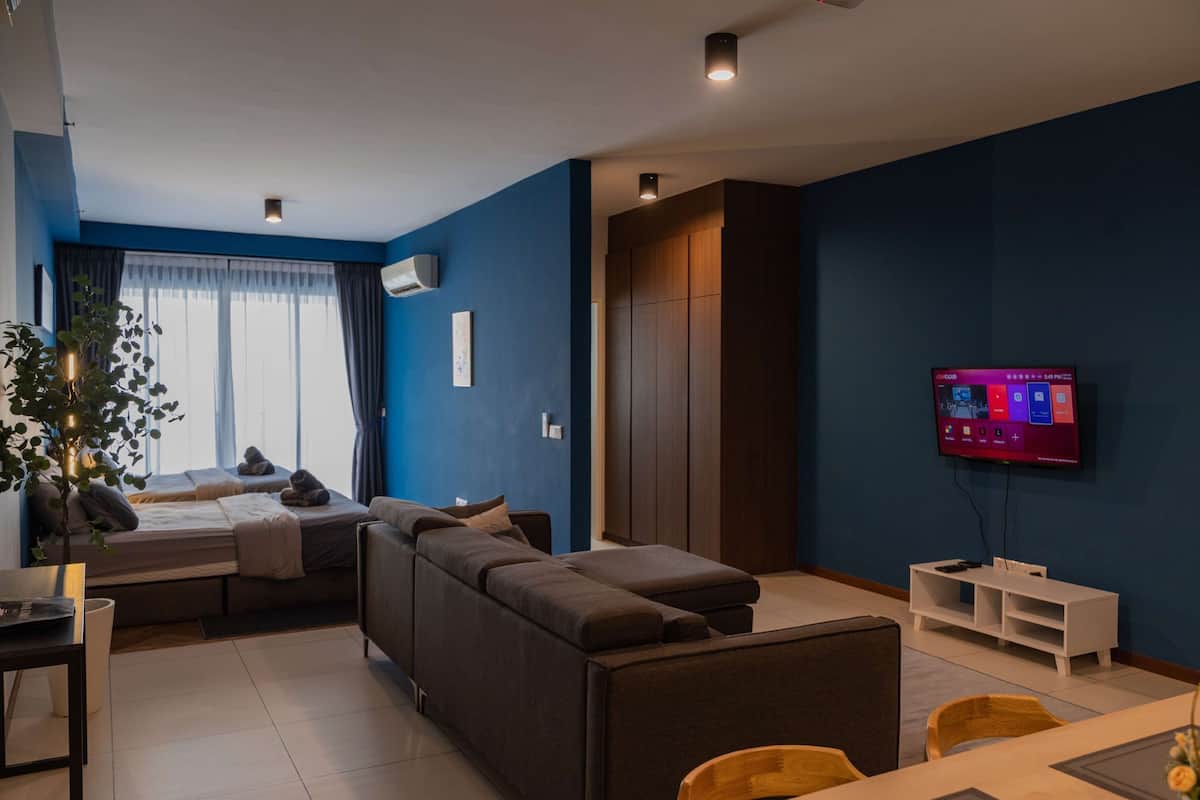 Ein modernes Wohnzimmer mit einer Couch, einem Essbereich und einem an der Wand befestigten Fernseher.
