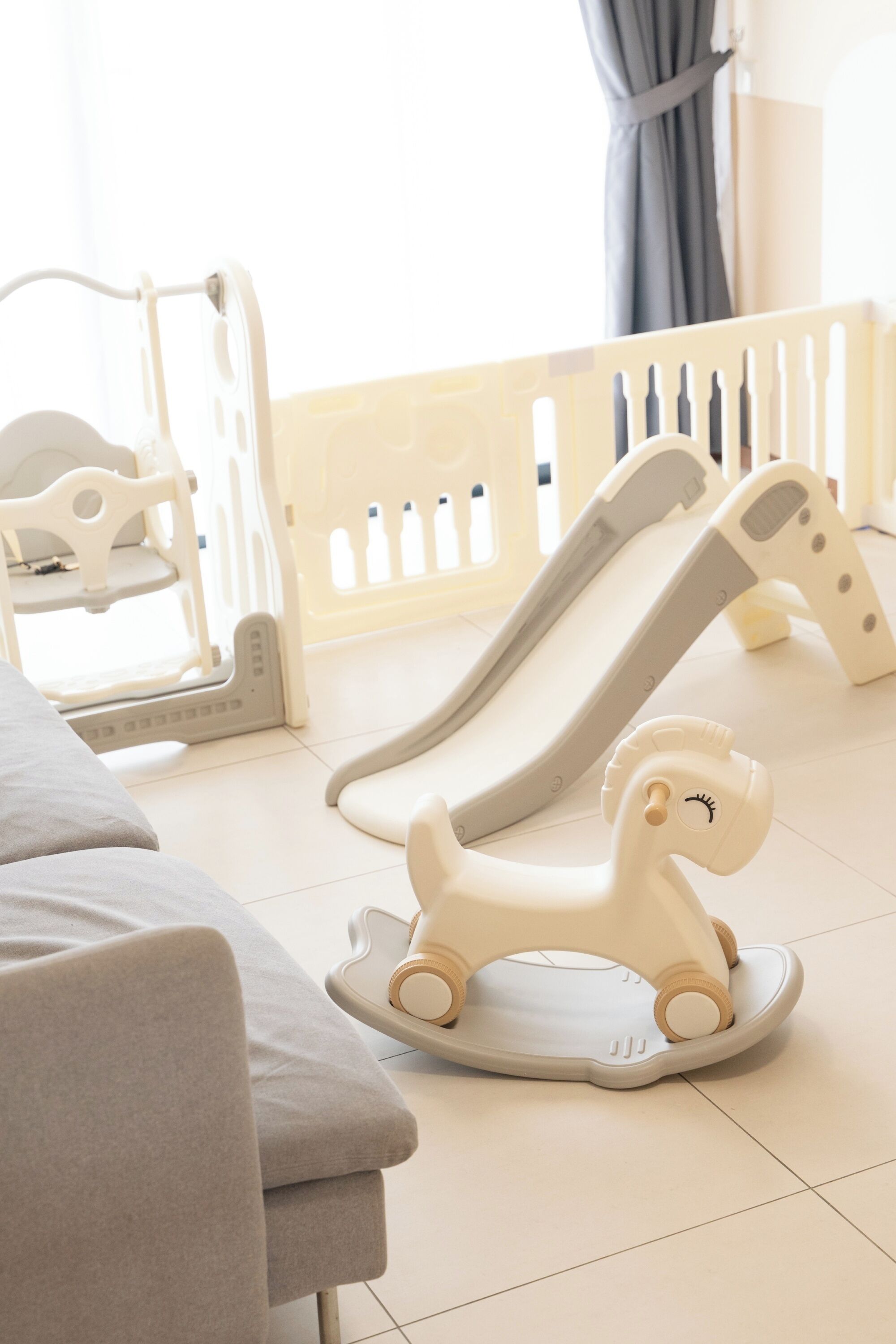 Zona de juegos para bebés con un tobogán y un caballo balancín.