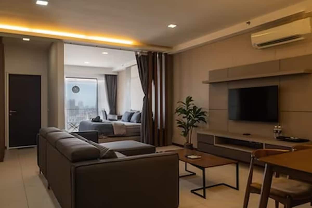 Ein modernes Wohnzimmer mit einer Couch, einem Couchtisch und einem Fernseher.
