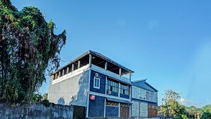 Ein modernes, zweistöckiges Haus mit Garage, umgeben von Grünflächen und einem Feldweg.