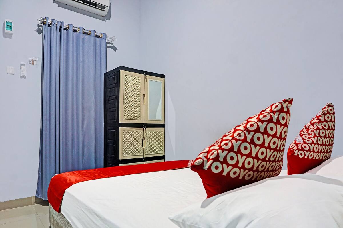 A hotel room with a bed, a wardrobe, and a bathroom.