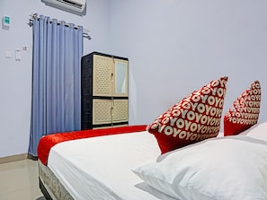 A hotel room with a bed, a wardrobe, and a bathroom.