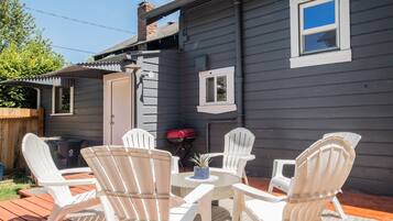 Una terraza con mobiliario exterior y una parrilla.