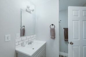 A bathroom with a white sink, a mirror, and a towel rack. - A beautiful home near OSU campus (Corvallis)