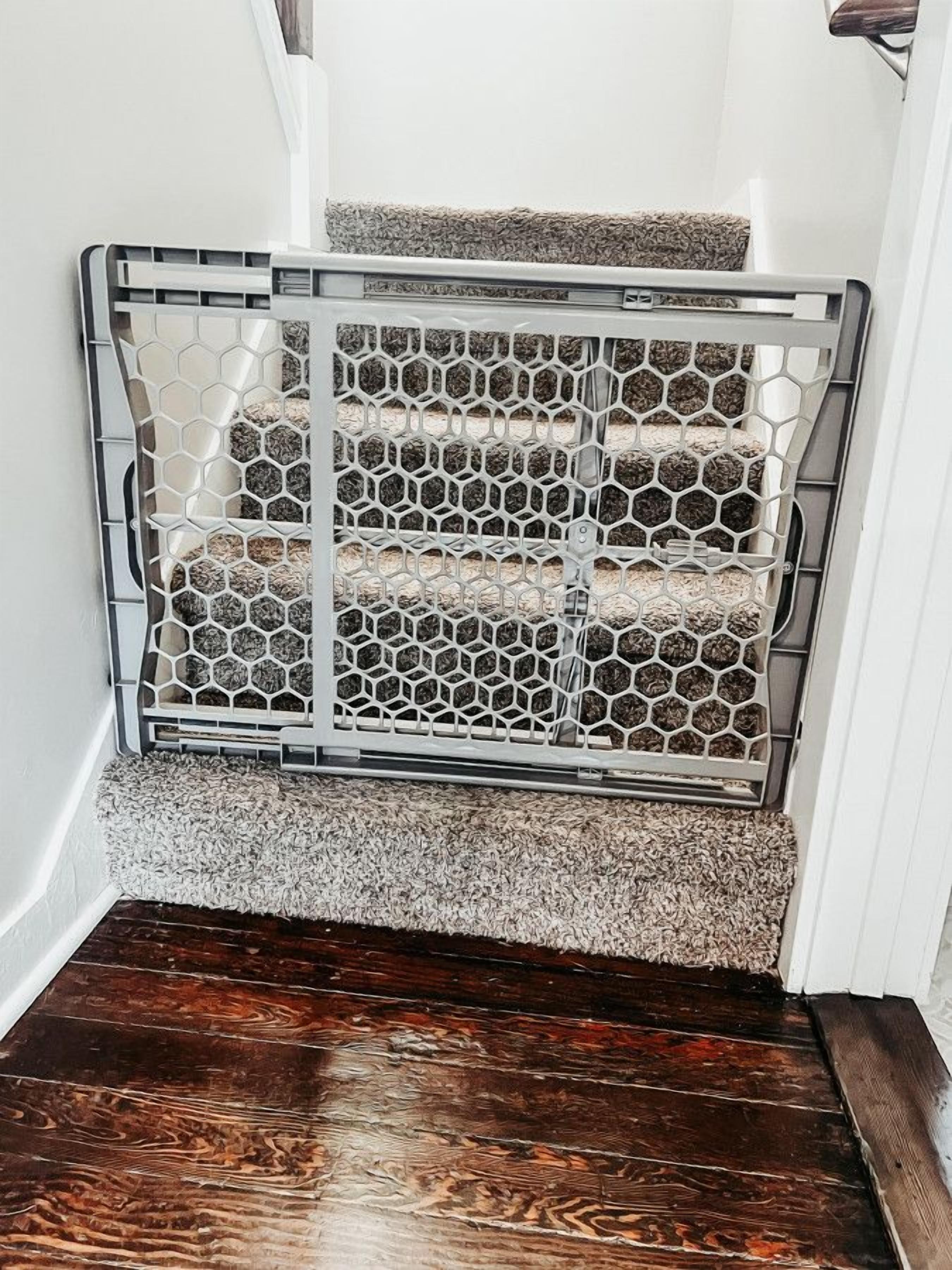 Una escalera con barandilla metálica y alfombra texturizada.