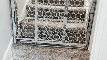 Una escalera con barandilla metálica y alfombra texturizada.