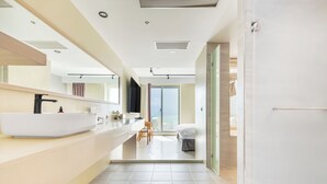 A modern bathroom with a large white sink, a mirror, and a shower area. - Jhai-Wu (Hengchun)