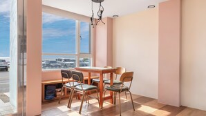 A dining area with a table and chairs, large windows, and a view of the street. - Jhai-Wu (Hengchun)