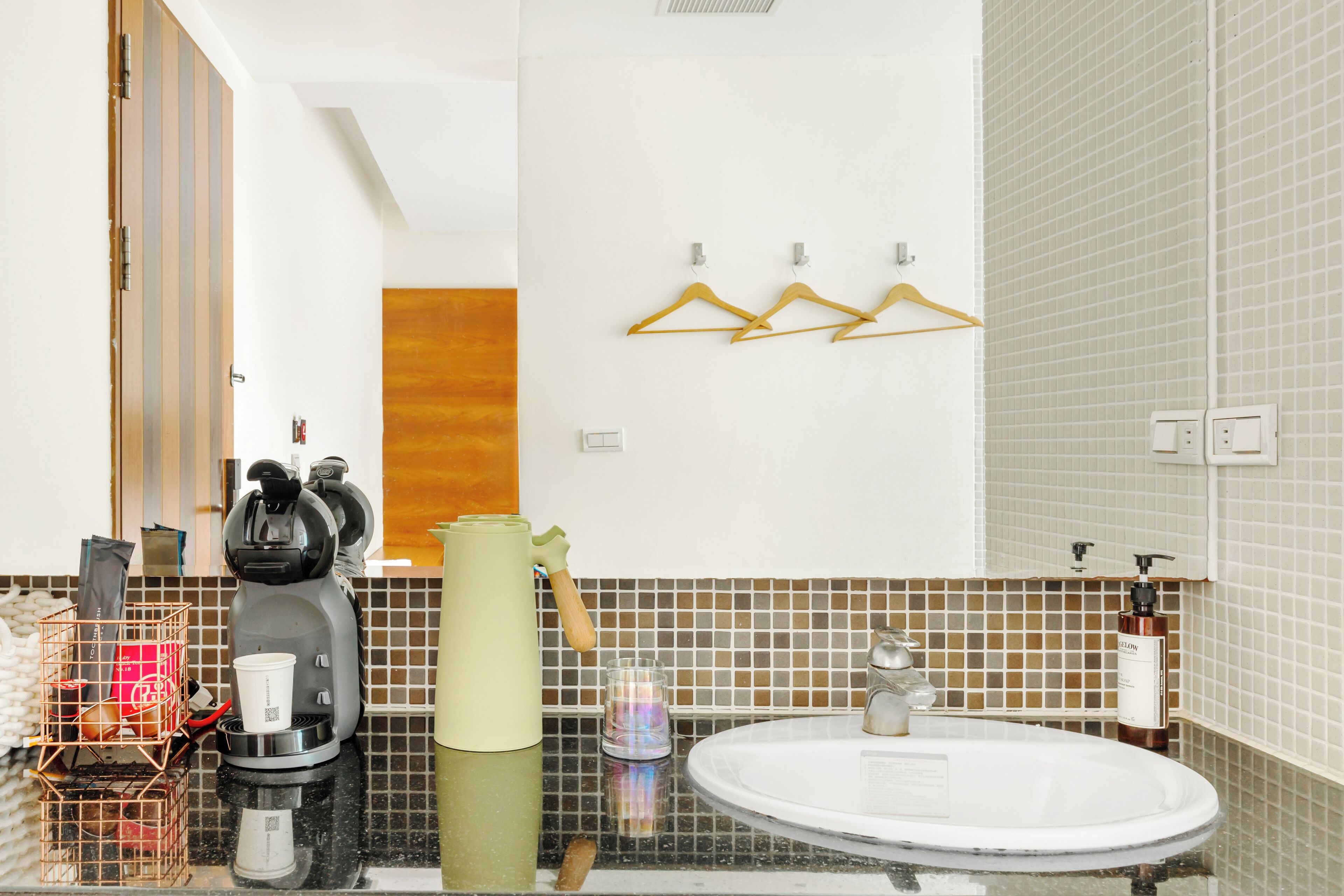 A modern bathroom with a coffee maker, a towel, and a sink.
