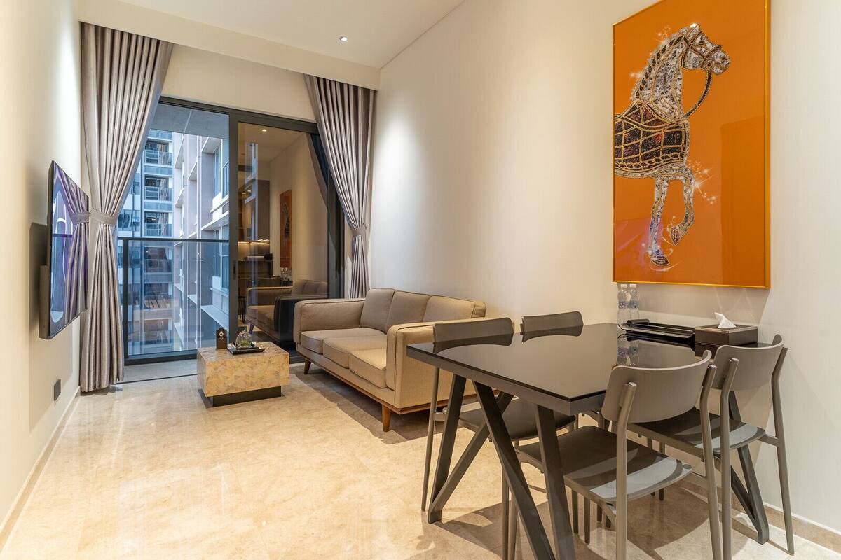 Un salon moderne comprenant un canapé, une table à manger avec des chaises, une table basse et une grande fenêtre avec des rideaux.