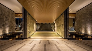 Een modern interieur met een centrale trap, stenen muren en een houten plafond.