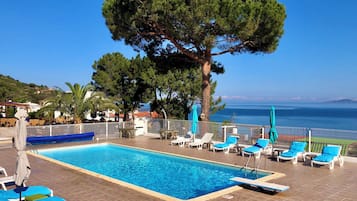 Piscine extérieure, parasols de plage, chaises longues