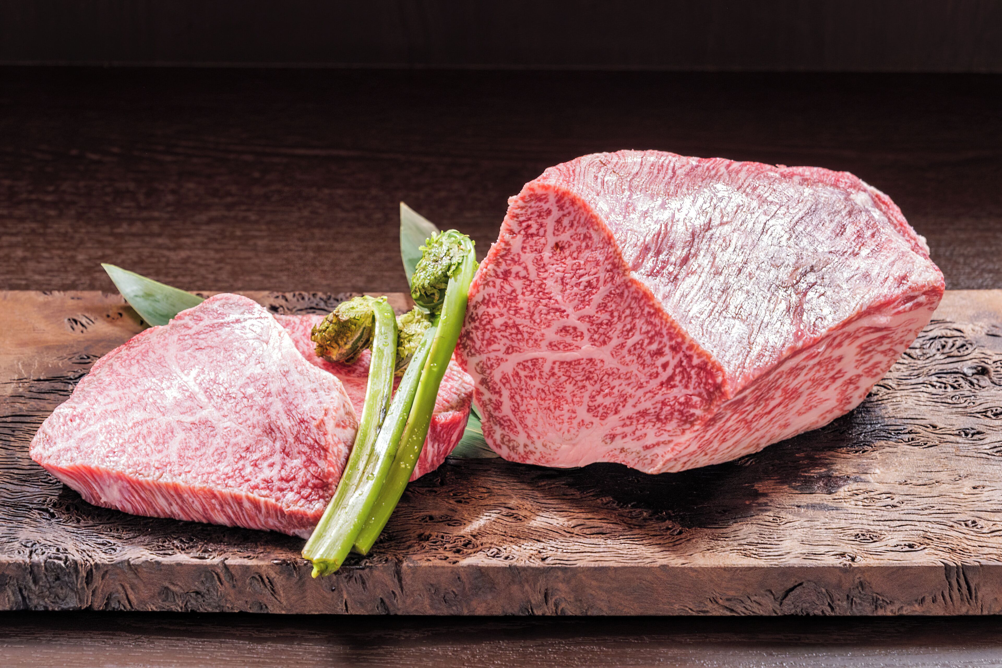 A steak with asparagus on a wooden board.