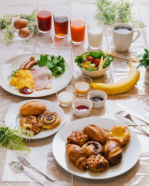 Een ontbijttafel met borden eten, drinken en een banaan.