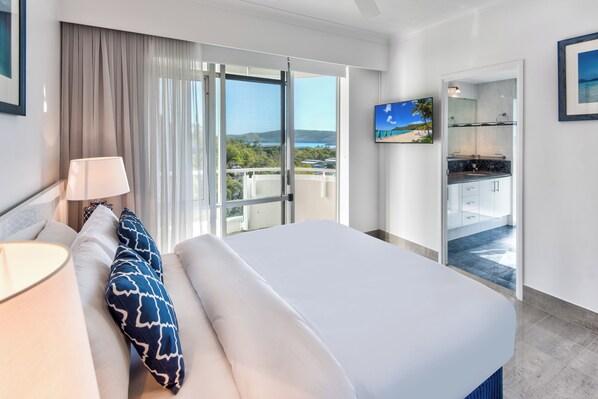 Une chambre d’hôtel avec un lit, une télévision, un balcon avec vue et une salle de bain avec douche.