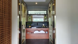 A modern bathroom with a wooden lattice partition, a black countertop, a mirror, and a window with blinds. - Warm Place (Zhangjiajie)