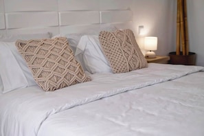 A bed with white bedding and two beige macramé pillows. - Casa dos Netos - villa with private pool (São Bartolomeu de Messines)