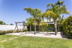 A garden with palm trees, a swing set, and a hammock. - Casa Gloria - Lovely farm house with private pool! (Alcantarilha)