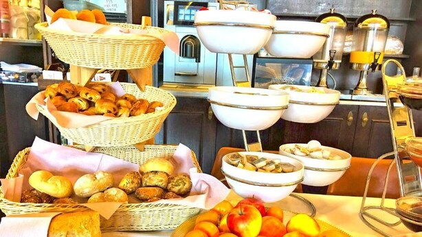 A buffet with various food items including bread, pastries, and fruits. - Hotel Mille Colonnes (Leuven)