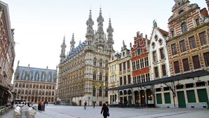 A historic square with ornate buildings, a central open area, and a few people walking. - Hotel Mille Colonnes (Leuven)