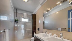 A modern bathroom with a glass shower enclosure, a large mirror, and a dual sink vanity. - Casa Ocean View - 180 degrees sea view (Carvoeiro)